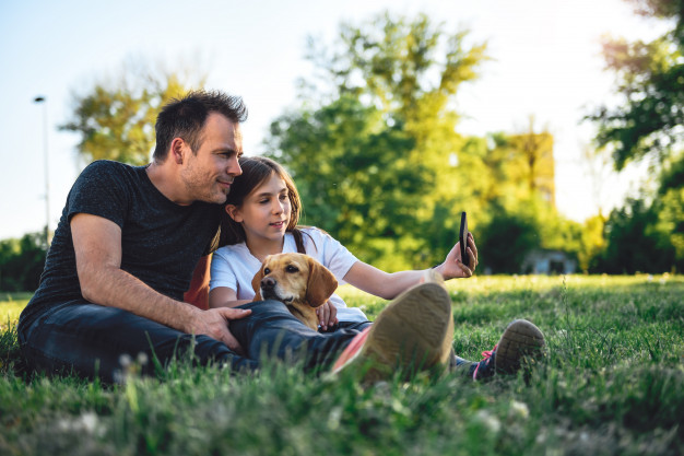 father-daughter-relaxing-park-with-dog_137573-1223